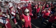 Temple mascot Hooter the Owl celebrating with the marching band and fans.