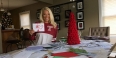 student Alison Boettlin holding up a holiday card with candy canes on it.