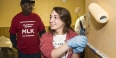 A student painting a wall as part of a service project. 