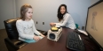 graduate student Zoe Ngo working with a child at a computer.