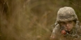 ROTC student in camouflage helmet training in the woods
