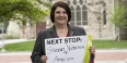 Tammy Barlet holding a sign that says "Next stop: Student Veterans of America."