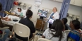 a nurse teaching students in a hospital room