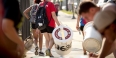 a student carrying a recycling bin