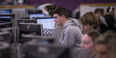 a student wearing a grey sweatshirt looks at a computer