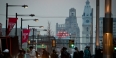 People crossing Broad Street on Temple’s campus with City Hall in the background