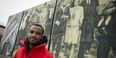 Hazim Hardeman standing in front of a mural near Main Campus. 