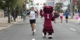 A man running on North Broad Street giving Hooter a high five as he passes by.