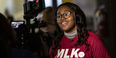 Image of a Black woman wearing a cherry and white MLK Day shirt.