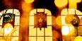 The sun shining through the stained glass windows of Mitten Hall's Great Court. 