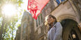 Jennifer Sierra standing under a Temple flag.