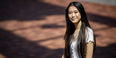 Michelle Wu wearing a white shirt and smiling outside of a building.