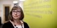  Andrea Vassar wearing glasses and standing in front of a sign that is blurred.