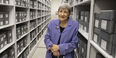 Image of Margery Sly in front of rows of gray boxes.