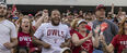 Image of a smiling college football fans wearing Temple-branded shirts.  