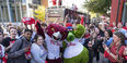 A group of smiling Temple students wearing red shirts and waving Red October towels celebrate the Philadelphia Phillies. 