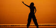 A student's silhouette shown performing at a Temple dance concert