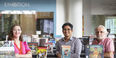Professors Christina Baker, César Cabezas and Augusto Lorenzino standing in front of books on display in Charles Library for Hispanic Heritage Month