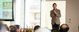 graduate student standing on stage with a mic