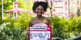 Jasmine Villaroel holding a Temple Made for sign outside on Main Campus
