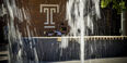 A student is pictured behind a fountain.
