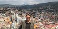 Alex Voisine standing in front of a cityscape. 