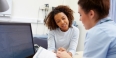 A patient meeting with a clinician in an office.