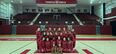  Image of Temple’s dance team wearing cherry and white posing in front of trophies.  