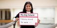 Smith holds a sign reading "My big future: Dancing around the world :)" in a dance studio