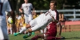 A Temple men's soccer player kicking the ball during a match.