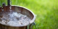 A bucket being filled with water from a well.