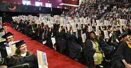 Tyler graduates holding up their Diploma Project print 