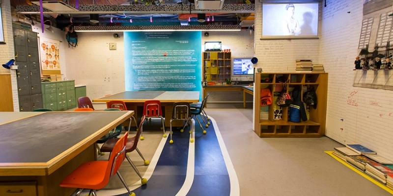 Tables and chair arranged to look like a classroom in the reForm exhibit. 