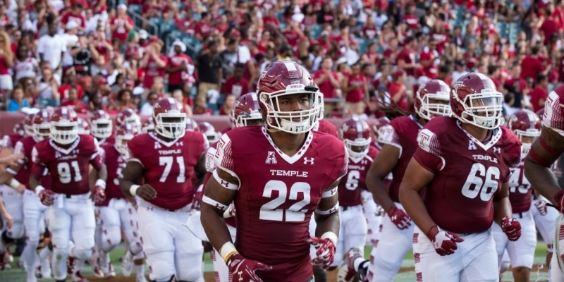 Football players run onto field before a sell-out crowd