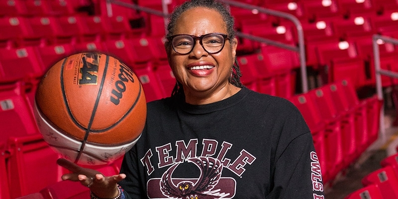 Professor Karen Turner poses with a basketball in the Liacouras Center.