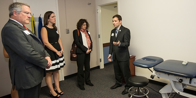 Temple President Neil D. Theobald tours the clinic with physical therapy students and CPH Dean Laura Siminoff