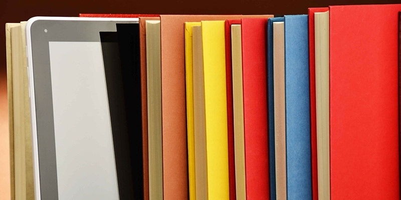 A stack of colorful books and an iPad.
