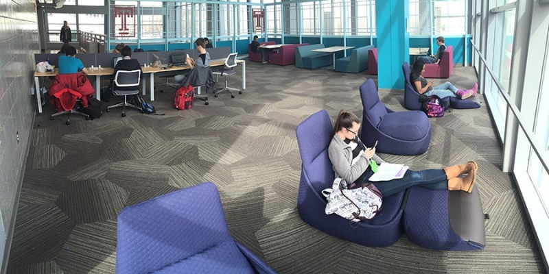 A female student sitting in a blue chair in the refurbished Owls’ Nest. 