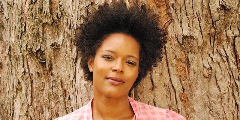 Yolanda Wisher posing in front of a tree.