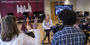 Journalism students and faculty working together in a classroom.