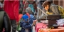 Woman handing candy to a little boy in costume during Avenue of Treats event