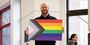 Jason Levy holding the Progress Pride flag