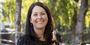 Juliet Curci wearing a navy blue blouse and smiling