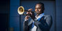 Image of Fareed Simpson-Hankins playing trumpet outside. 