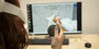 A student using virtual reality technology at a computer to illustrate