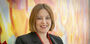 Erika Tapp Duran standing against a colorful background