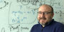 Associate Professor of Biology Vincenzo Carnevale in front of white board with equations