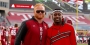 Two men standing on the sideline of a Temple football game.