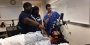 Two medical students showing middle school students a procedure in the hospital. 