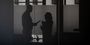Two profiled silhouettes of two staff members talking with each other.